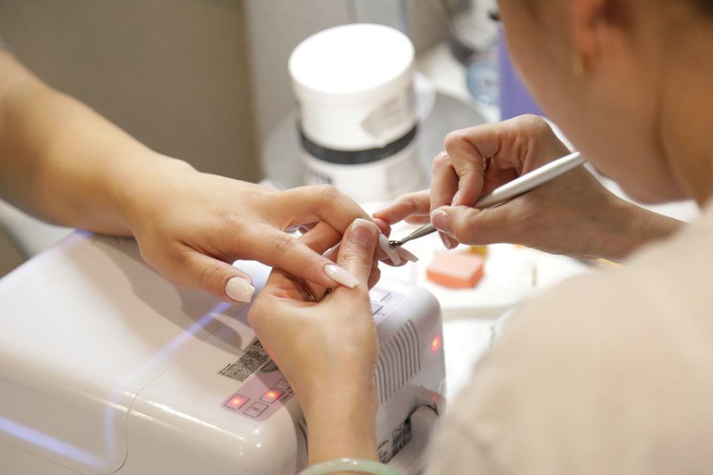 a-woman-getting-her-nails-done-at-a-nail-salon-gb6gtitzkb8